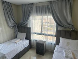 a bedroom with two twin beds and a window at Casa Hamburg in Nador