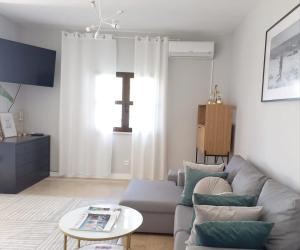 uma sala de estar com um sofá e uma mesa em Feliz Algarve em Albufeira