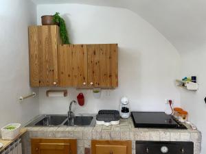 a kitchen with a sink and a laptop on a counter at 'Il Caratteristico' (centro storico) in Capistrello