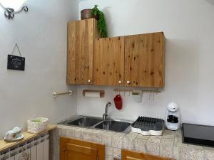 a kitchen with a sink and a wooden cabinet at 'Il Caratteristico' (centro storico) in Capistrello