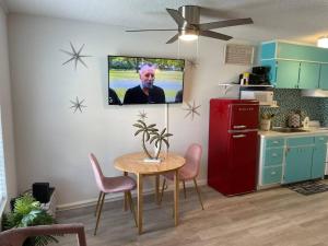 a kitchen with a table and a red refrigerator at Gulf Shores Getaway steps away from the pool! in Gulf Shores