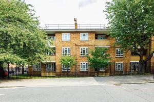 a brick building with a fence in front of it at Spacious 2 bedrooms in peaceful green area in London