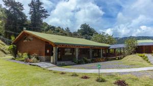 um edifício de madeira com um telhado verde num campo em Hacienda La Lucha 