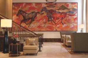 a lobby with a painting of horses on the wall at The Ritz-Carlton, Vienna in Vienna