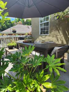 un patio con mesa, sillas y sombrilla en Tranquility at the House of Alchemy Hollywood, en Los Ángeles