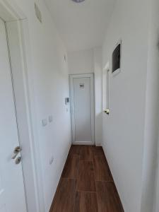 an empty hallway with a door and a wooden floor at Lazarov Apartments in Nov Dojran