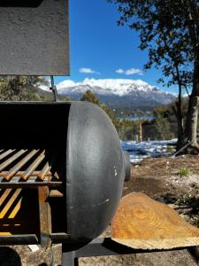 um barril sentado em cima de uma grelha com montanhas em Casa Silente em San Carlos de Bariloche