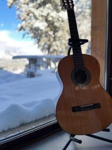 uma guitarra sentada numa bancada em frente a uma janela em Casa Silente em San Carlos de Bariloche