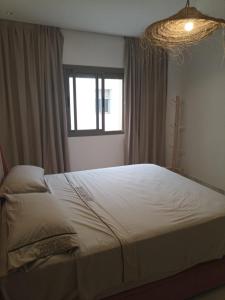 a bedroom with a large bed with a window at Appartement luxueux proche de tout in Fez