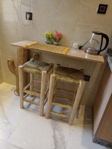 a kitchen with a table and two stools at Appartement luxueux proche de tout in Fès