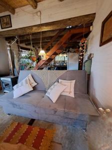 a couch with pillows on it in a room at Cabañas Bahia Serena in Punta Del Diablo