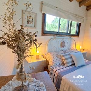a bedroom with a bed and a table with a vase at Cabañas Bahia Serena in Punta Del Diablo