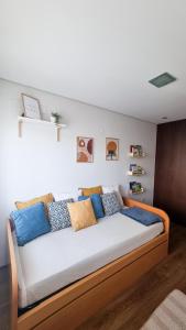 a large bed with blue and yellow pillows on it at Apartament F&M in Braga