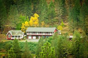 ein großes rotes Haus mitten im Wald in der Unterkunft Hearthstone Elegant Lodge in Kamiah