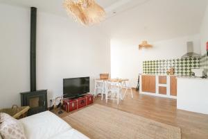 uma sala de estar com um sofá, uma televisão e uma cozinha em Quinta do Freixo em Elvas