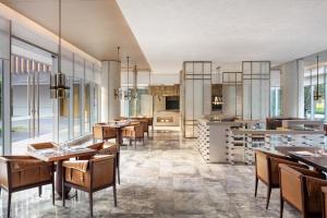順德的住宿－顺德美的臻品之选酒店，用餐室设有桌椅和窗户。