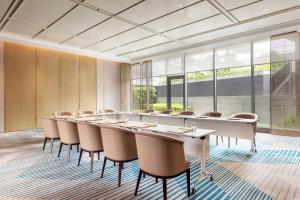 una gran sala de conferencias con una mesa larga y sillas en Midea Shunde, a Tribute Portfolio Hotel, en Shunde