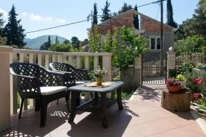 a patio with two chairs and a table and a fence at Apartments Marina in Zaton