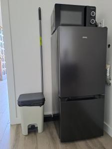 einen schwarzen Kühlschrank mit einer Mikrowelle darüber in der Unterkunft M&P - Tres Marias Apartments in Redondela