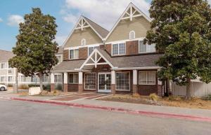 a large brick house on the corner of a street at Extended Stay America Suites - Dallas - Plano Parkway in Plano