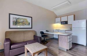ein Wohnzimmer mit einem Sofa und einem Schreibtisch in einem Zimmer in der Unterkunft Extended Stay America Suites - Dallas - Plano Parkway in Plano