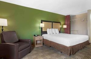 a hotel room with a bed and a chair at Extended Stay America Suites - Houston - Galleria - Uptown in Houston