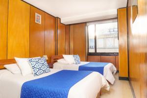 a room with two beds and a window at Hotel San Francisco in Tunja