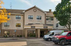 a building with a van parked in front of it at Extended Stay America Suites - Detroit - Metropolitan Airport in Romulus