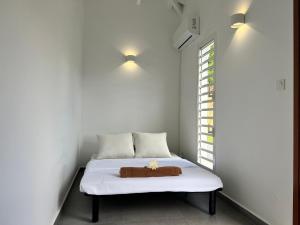 Cama en habitación con ventana en Bienvenue à la Villa Ifè en Le Gosier