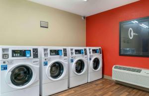 two washing machines in a laundry room with red walls at Extended Stay America Suites - Detroit - Metropolitan Airport in Romulus