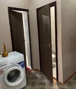 lavadero con lavadora y espejo en Artina Guest House, en Tatʼev