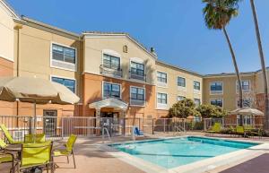a hotel with a pool and chairs and a building at Extended Stay America Suites - San Ramon - Bishop Ranch - East in San Ramon