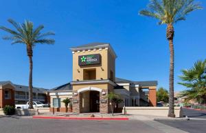 a hotel with palm trees in front of a building at Extended Stay America Select Suites - Phoenix - Airport - E Oak St in Phoenix