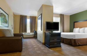 a hotel room with a bed and a flat screen tv at Extended Stay America Suites - Phoenix - Airport - E Oak St in Phoenix