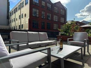 a couch and two chairs on a table on a patio at Luxury 2 Bed 2 Bath Central Manchester in Manchester