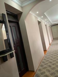 un pasillo con paredes blancas y una puerta en Artina Guest House, en Tatʼev