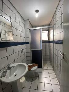 a bathroom with a toilet and a sink and a shower at Residencial Leticia in Florianópolis