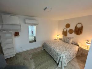 Un dormitorio blanco con una cama y un espejo. en Apartamentos Los Cabezuelos, Dream Views, en Arcos de la Frontera