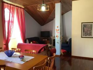 ein Esszimmer mit einem Tisch und einem Sofa in der Unterkunft Casa das Camélias in Gouveia