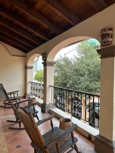 une terrasse couverte avec des fauteuils à bascule sur un balcon dans l'établissement Hermosa casa estilo Mexicano, à Monterrey