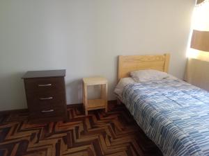 1 dormitorio con 1 cama, vestidor y mesita de noche en Nuevo Chez Julie 2, LA casa de Julie, en Arequipa