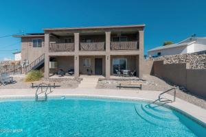 a house with a swimming pool in front of a building at Horror House- arcade & heated pool! Room for all! in Lake Havasu City