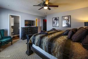 een slaapkamer met een bed en een plafondventilator bij Horror House- arcade & heated pool! Room for all! in Lake Havasu City