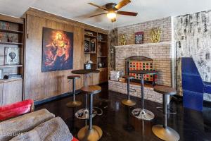 un bar con taburetes en una sala con chimenea en Horror House- arcade & heated pool! Room for all! en Lake Havasu City