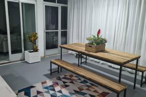 sala de estar con mesa de madera y bancos en Casa da Miss, en Florianópolis