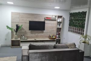 sala de estar con sofá y TV de pantalla plana en Casa da Miss, en Florianópolis