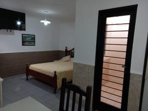 a bedroom with a bed and a door with a window at La juramento in San Miguel de Tucumán