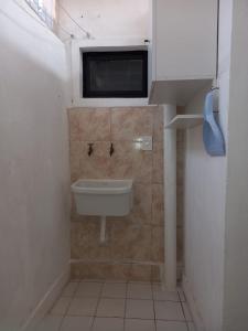 a bathroom with a sink and a tv on the wall at La juramento in San Miguel de Tucumán