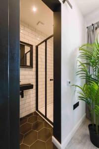 a bathroom with a shower and a sink and a mirror at SleepLuxury ApartHOUSE in Glasgow