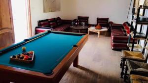 - un salon avec un billard et des canapés dans l'établissement Chez Billy, Villa moderne avec piscine privé, à Agadir